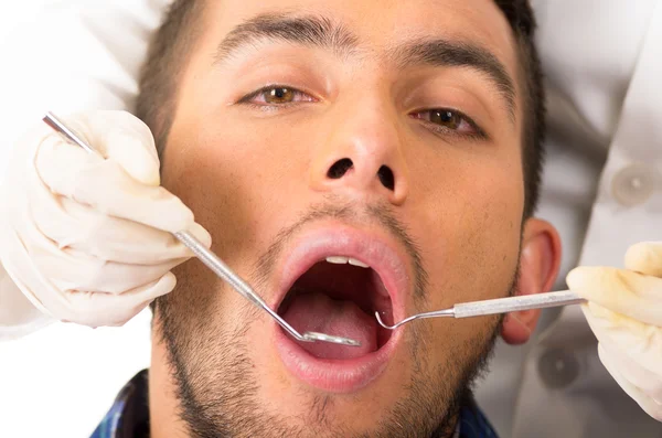 Primer plano retrato de joven guapo hombre en el dentista — Foto de Stock