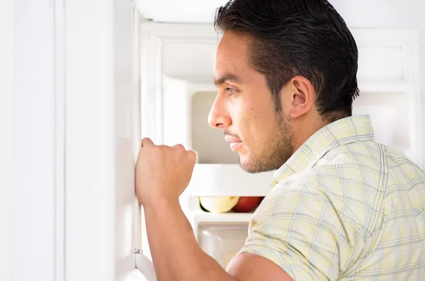 Young handsome man looking for food in the fridge — Stock Photo, Image