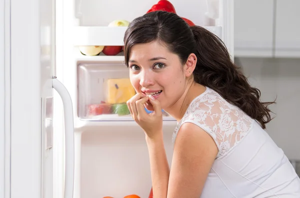 Junge schöne Frau auf der Suche nach Nahrung im Kühlschrank — Stockfoto