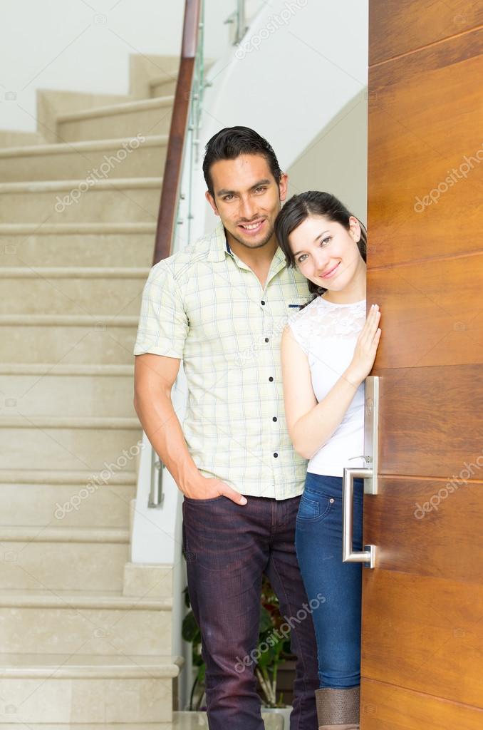 happy attractive couple opening the door to their new house