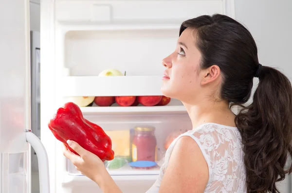 Молода красива жінка шукає їжу в холодильнику — стокове фото
