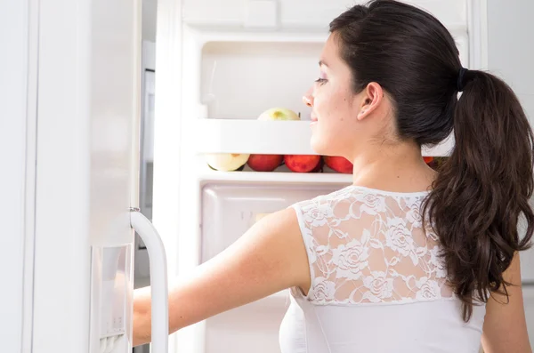 young beautiful woman searching for food in the fridge