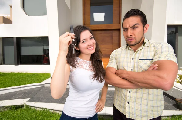 Suspicious husband looking at wife holding key to their house — Stock Photo, Image