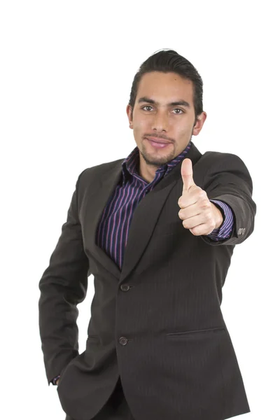 Elegante hombre latino confiado en un traje haciendo gestos de victoria sosteniendo el pulgar hacia arriba — Foto de Stock