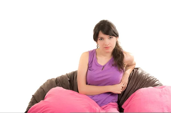 Bonita chica joven con pijama sentado con almohada rosa —  Fotos de Stock