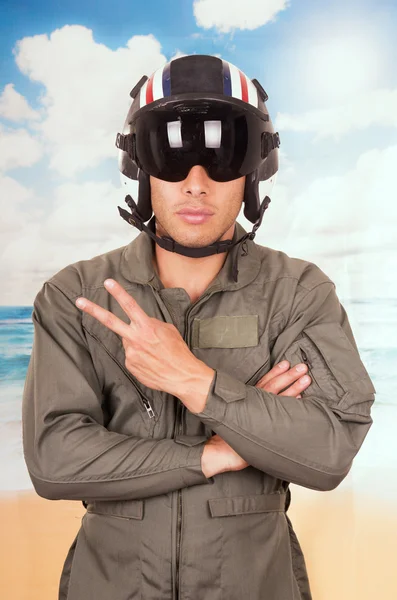 ハンサムな若いパイロットの制服やヘルメットを着てビーチの背景の上 — ストック写真