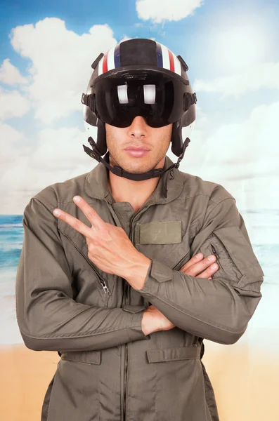 Junge hübsche Pilot trägt Uniform und Helm über Strand Hintergrund — Stockfoto