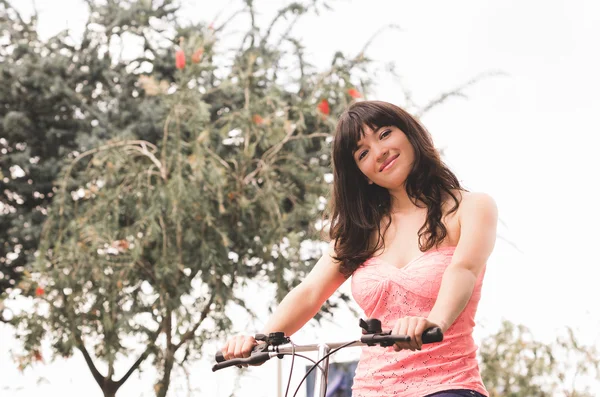 Hermosa joven bicicleta de montar en el parque — Foto de Stock