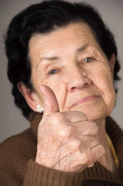 Primer plano retrato de la abuela anciana sosteniendo el pulgar hacia arriba —  Fotos de Stock