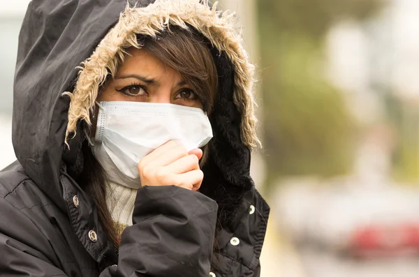 Niña caminando con chaqueta y una máscara en la ciudad concepto de la calle de la contaminación —  Fotos de Stock