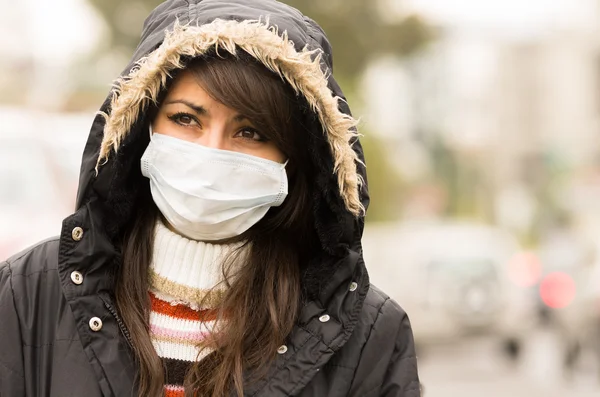 Niña caminando con chaqueta y una máscara en la ciudad concepto de la calle de la contaminación —  Fotos de Stock