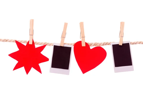 Instant photographs and red shapes hanging on a rope clothesline — Stock Photo, Image