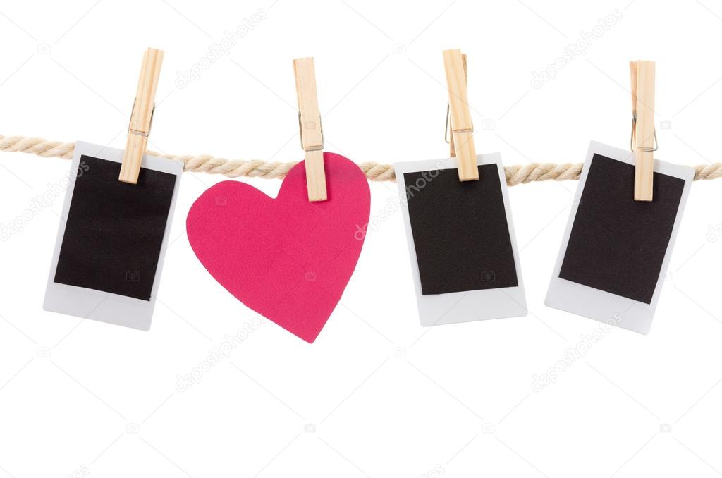 instant photographs and heart shape hanging on a rope clothesline