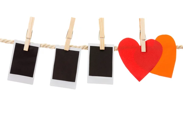 Instant photographs and heart shapes hanging on a rope clothesline — Stock Photo, Image