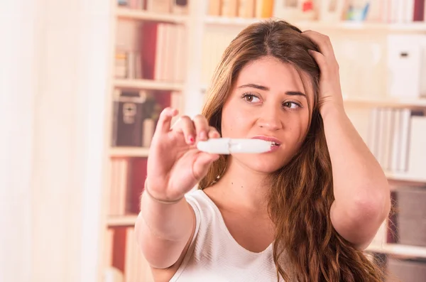Нервная молодая девушка проводит тест на беременность — стоковое фото