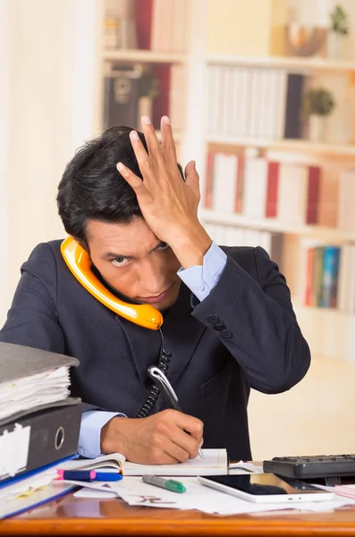 Jeune homme accablé stressé avec des piles de dossiers sur son bureau — Photo