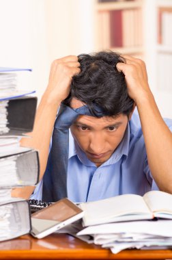 Genç klasörleri masasının üzerindeki yığınları ile bunalmış adam vurguladı