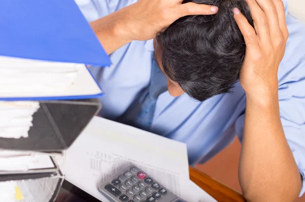 Jeune homme accablé stressé avec des piles de dossiers sur son bureau — Photo