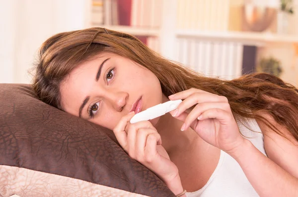 Nervózní mladá dívka drží těhotenský test — Stock fotografie
