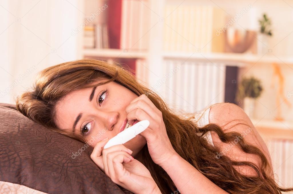 nervous young girl holding pregnancy test