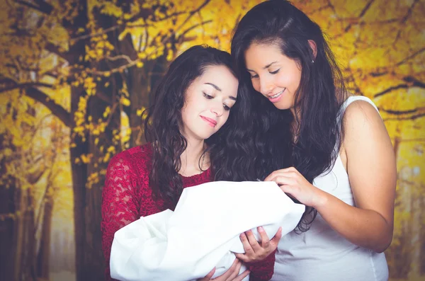Portrait of beautiful lesbian couple holding their baby — Stock Photo, Image