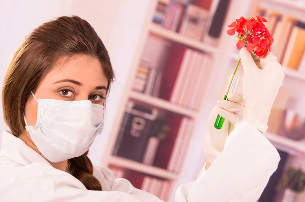 Jovem biólogo feminino experimentando com flor vermelha — Fotografia de Stock
