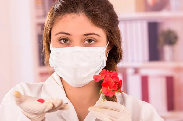 Joven bióloga experimentando con la flor roja — Foto de Stock