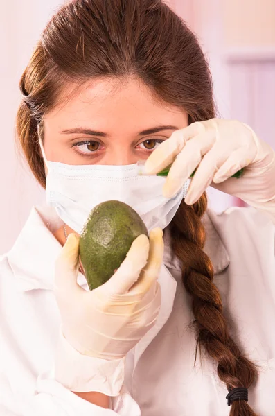 Young beautiful woman biologist experimenting with avocado — Stock Photo, Image