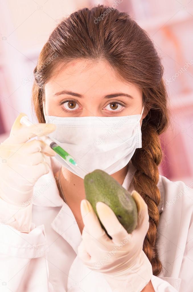 young beautiful woman biologist experimenting with avocado