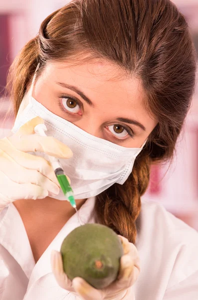 Young beautiful woman biologist experimenting with avocado — Stock Photo, Image