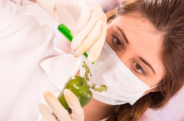 Young beautiful woman biologist experimenting with green pepper — Stock Photo, Image