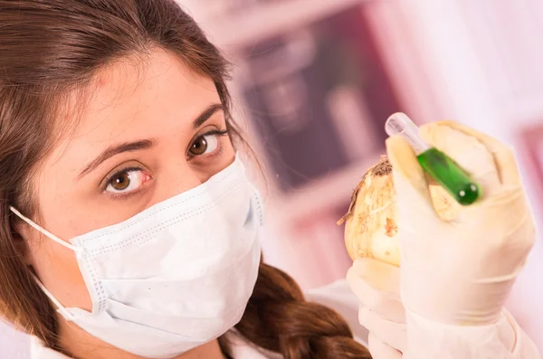 Young beautiful woman biologist experimenting with white onion — Stock Photo, Image