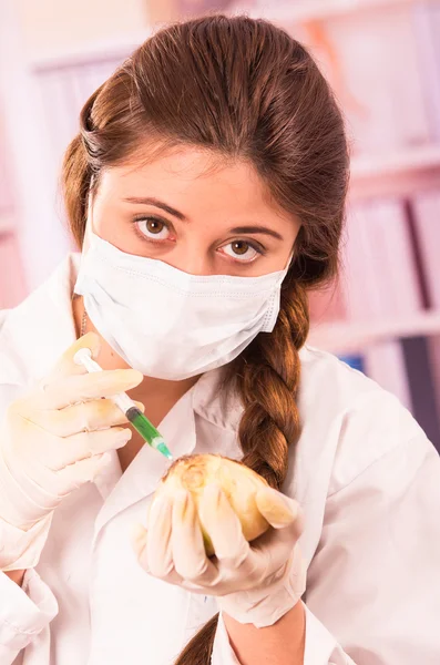 Joven hermosa mujer bióloga experimentando con cebolla blanca Imágenes de stock libres de derechos