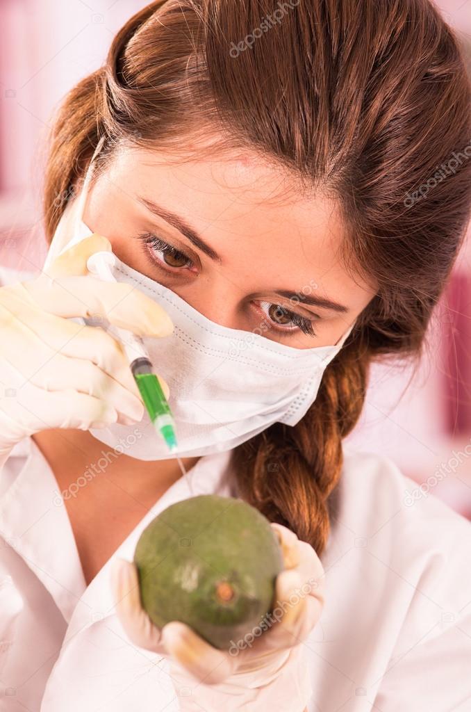 young beautiful woman biologist experimenting with avocado