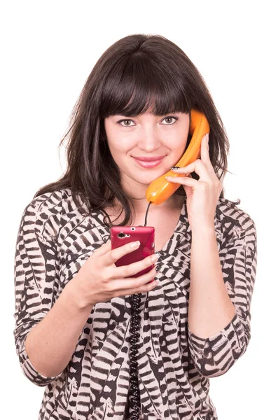 Beautiful young woman using retro orange and mobile phone telephone — Stock Photo, Image