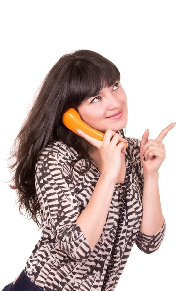 Mooie jonge vrouw via retro oranje telefoon — Stockfoto