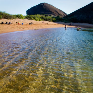 Kimliği belirsiz turist Galapagos Adaları'nda kristal berraklığında su ile güzel bir plaj keyfi