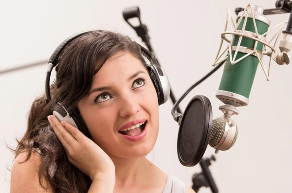 Beautiful young girl singing in music studio — Stock Photo, Image