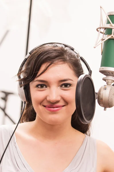 Beautiful young girl singing in music studio — Stock Photo, Image