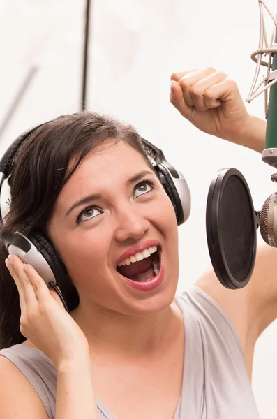 Beautiful young girl singing in music studio — Stock Photo, Image