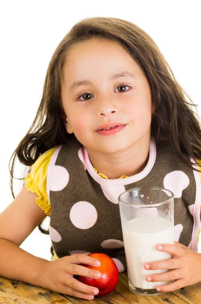 Cute little preschooler girl drinking a glass of milk and eating an apple — Stock Photo, Image