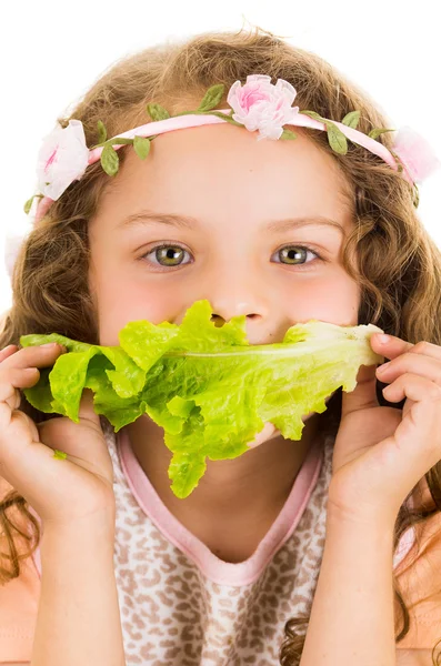 Beautiful healthy little curly girl enjoying eating a lettuce leaf — Stock Photo, Image