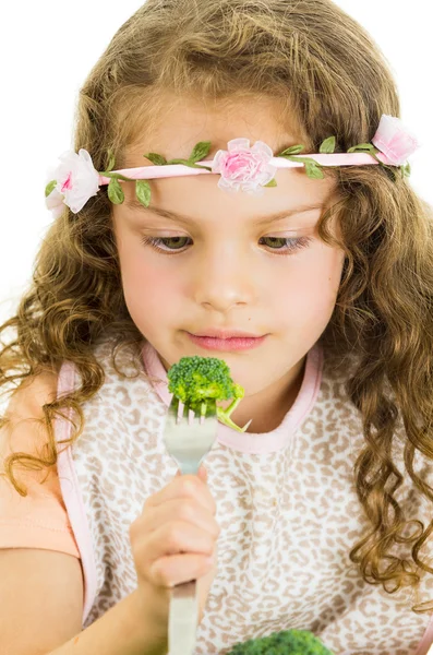 Beautiful healthy little curly girl enjoying eating broccoli — Stock Photo, Image