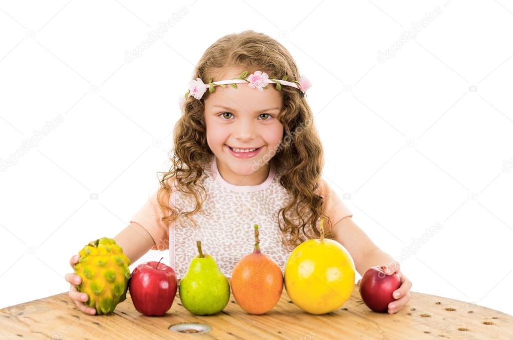 Cute little preschooler girl with fruits on the table