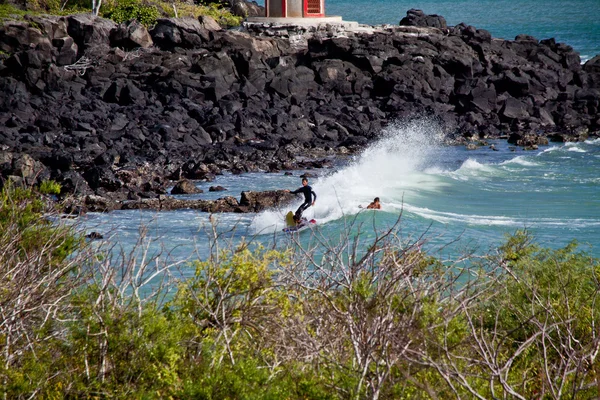 Ongeïdentificeerde man surfen in Mann strand, San Cristobal eiland, Galapagos — Stockfoto