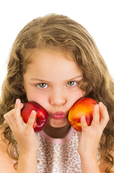 Cute little preschooler girl holding two peaches — Stock Photo, Image