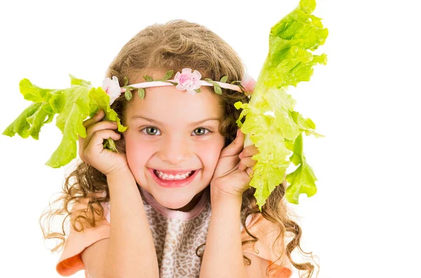 Beautiful healthy little curly girl enjoying playing with lettuce leaves — Stock Photo, Image