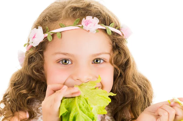Güzel sağlıklı küçük kıvırcık kız bir marul yeme keyfini — Stok fotoğraf