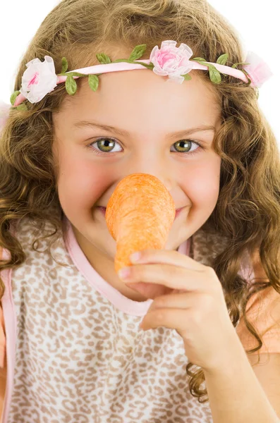 Beautiful healthy little curly girl enjoying playing with a carrot — Stock Photo, Image
