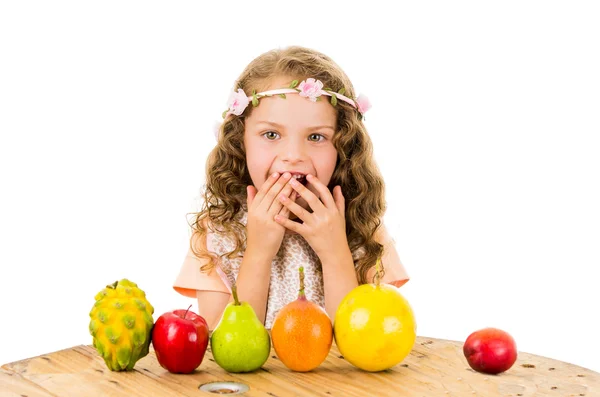 Söt liten förskolebarn flicka med frukter på bordet — Stockfoto